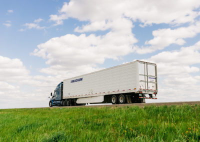 Magnum Truck and Trailer with green grass and blue sky